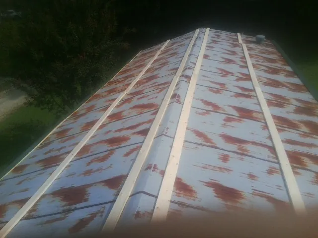 Rusted metal roof panels with new wood purlins before replacement — Storm Damage Roof Repair in Waveland by Roofing Brothers