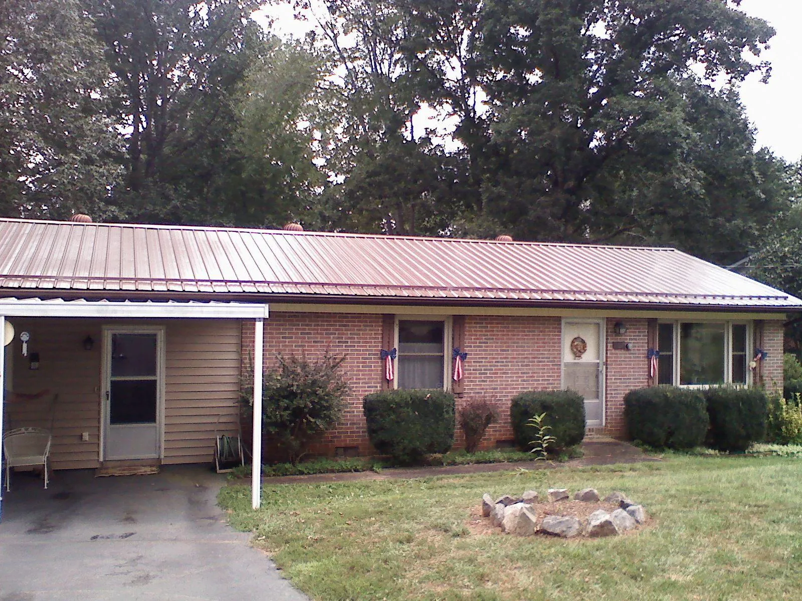 Bronze metal roof and carport on a brick ranch home — Roof Repair work by our crew in Waveland